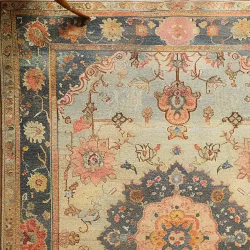 Close-up view of a magnificent floral hand-knotted area rug, showcasing intricate Persian-inspired patterns and vintage charm. The soft hues and elaborate designs make it a perfect choice for living room area rugs, adding elegance and warmth to any space.