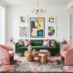 Modern living room with a green sofa, pink chairs, a floral wool rug, and colorful artwork.