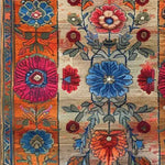 Close-up view of the Maharaja Garden Hand Tufted Area Rug, showcasing a vibrant floral pattern with rich blue, pink, and orange hues. Perfect for adding a touch of elegance to dining rooms and bedrooms, this wool rug brings a luxurious feel to any space.