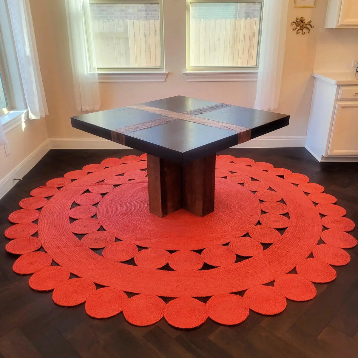 Stylish round jute area rug in vibrant red, perfect for large living rooms. The rug's intricate circular design adds a touch of elegance, enhancing any living room setting.