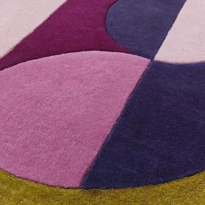 Close-up of the Maia Golden Pink Round Hand Tufted Wool Rug showcasing its vibrant abstract design in shades of pink, purple, and golden yellow. Perfect for adding a contemporary touch to your living room, this large area rug combines style and comfort, ideal for those seeking unique living room rugs 8x10.