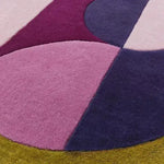 Close-up of the Maia Golden Pink Round Hand Tufted Wool Rug showcasing its vibrant abstract design in shades of pink, purple, and golden yellow. Perfect for adding a contemporary touch to your living room, this large area rug combines style and comfort, ideal for those seeking unique living room rugs 8x10.