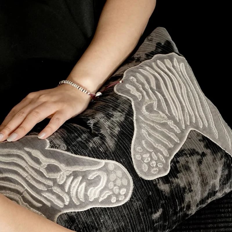 Luxurious throw pillow with zebra embroidery in black and gray, perfect for adding elegance to any decor.