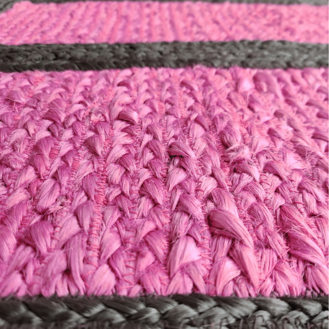 Infuse your space with bold contrast using this black and pink braided jute rug. The intertwining colors create a dynamic visual appeal, while the natural texture of jute adds warmth and character. Perfect for adding a playful yet sophisticated touch to any room.