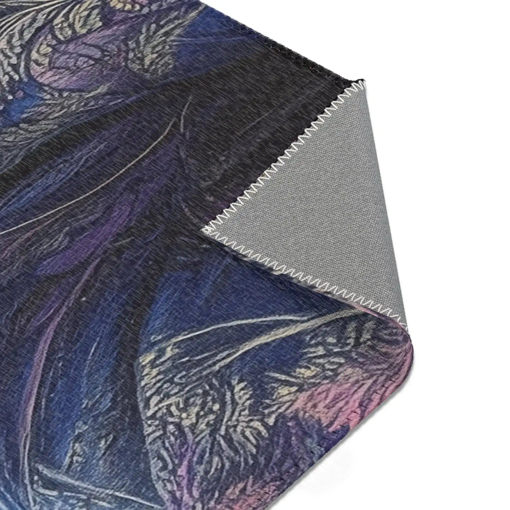 Folded corner of Majestic Monarch Regal Monkey Accent Rug showing dark blue coat with decorative pattern and gray backing