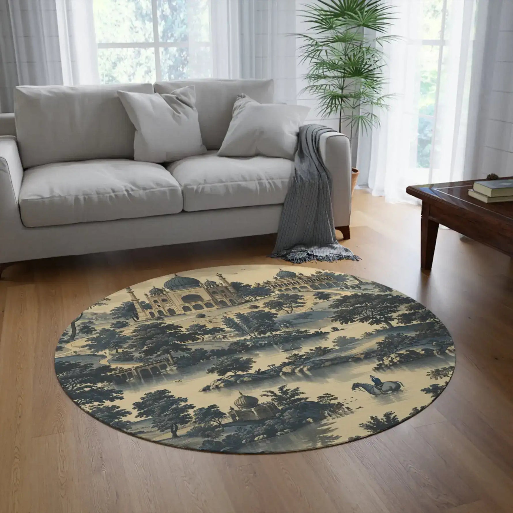 Majestic Palace and Landscape Blue and Beige Round Rug in bright natural living room with grey sofa, palm plant, and wooden coffee table