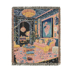 Fringed woven throw in square format showing maximalist interior with chandelier blue floral walls pink sofa and Persian rug on the Maximalist Dreamscape Woven Blanket