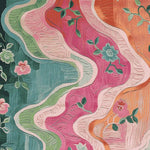 Vibrant area rug with a dynamic floral design, featuring swirling patterns in shades of pink, green, and orange. This wool rug is perfect for adding a touch of elegance to large living rooms. Suitable as a large 8x10 living room rug, it showcases intricate floral details that bring a meadow in motion to your home.