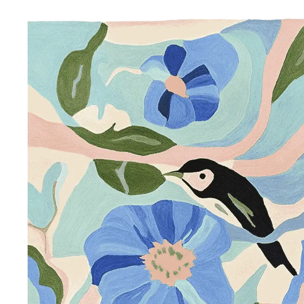 A beautifully designed area rug featuring a contemporary style with vibrant blue flowers and green leaves, complemented by a black and white bird motif. This wool rug adds a touch of elegance and nature-inspired charm to any living room.