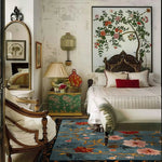 A luxurious Meadow Muse Hand Tufted Area Rug elegantly placed in a vintage-style living room. This wool rug features a vibrant floral pattern, offering a touch of classic charm and sophistication. Perfect for enhancing the aesthetic of any living room, this vintage rug adds warmth and style to your space.