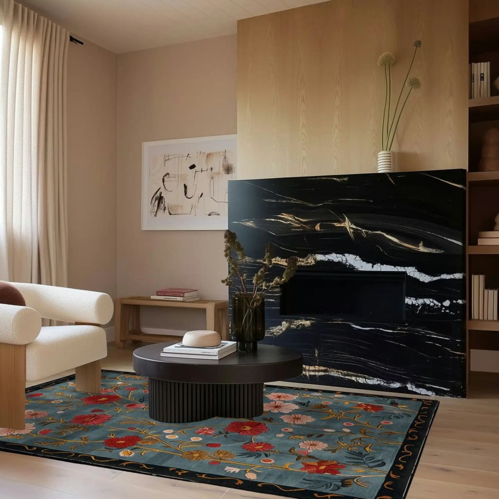 A cozy living room featuring a Meadow Muse Hand Tufted Area Rug. This wool rug showcases a vintage floral design in rich colors, perfect for adding warmth and charm to your living room. The elegant rug lies in front of a modern black marble fireplace, complementing the contemporary decor.