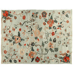 This beautiful hand-knotted area rug features meandering floral vines in vibrant shades of red, orange, and green, set against a soft, neutral background. Perfect for adding a touch of elegance to your living room, this 8x10 wool rug combines timeless floral patterns with contemporary style, making it an ideal choice for area rugs for living room spaces.