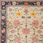 This image showcases a Medallion Bloom Hand Knotted Area Rug, featuring a beautiful floral pattern with vibrant pink, yellow, and blue flowers. The intricate border design evokes a vintage Persian rug style, making it perfect for large living rooms. This elegant floral rug is an exquisite addition to any space, enhancing the aesthetic of rugs for living room decor.