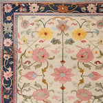 This image showcases a Medallion Bloom Hand Knotted Area Rug, featuring a beautiful floral pattern with vibrant pink, yellow, and blue flowers. The intricate border design evokes a vintage Persian rug style, making it perfect for large living rooms. This elegant floral rug is an exquisite addition to any space, enhancing the aesthetic of rugs for living room decor.
