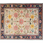 The Medallion Bloom Hand Knotted Area Rug features an intricate floral design with vibrant pink, yellow, and green patterns on a cream background. Perfect for large living rooms, this vintage Persian-style rug adds elegance and charm. Ideal as a centerpiece in any space, it embodies the essence of classic rugs for living rooms.