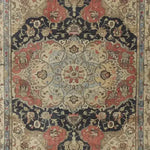 A beautifully intricate Medallion Majesty Hand Knotted Area Rug featuring a vintage Persian design. The rug showcases a floral pattern with rich red, navy, and cream colors, perfect for adding elegance to living room spaces. This 8x10 wool rug embodies the charm of traditional living room area rugs, ideal for those seeking a classic yet luxurious touch.