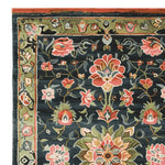 Close-up view of the Midnight Bloom Mosaic Hand Tufted Area Rug showcasing its intricate floral design. This wool rug features vibrant red and pink flowers against a dark backdrop, perfect as a large living room rug, adding elegance and style to any area.