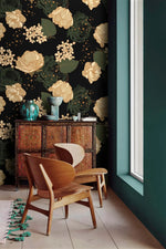 Midnight blooms floral wallpaper accent wall with carved cabinet, wood chairs and teal vases by window