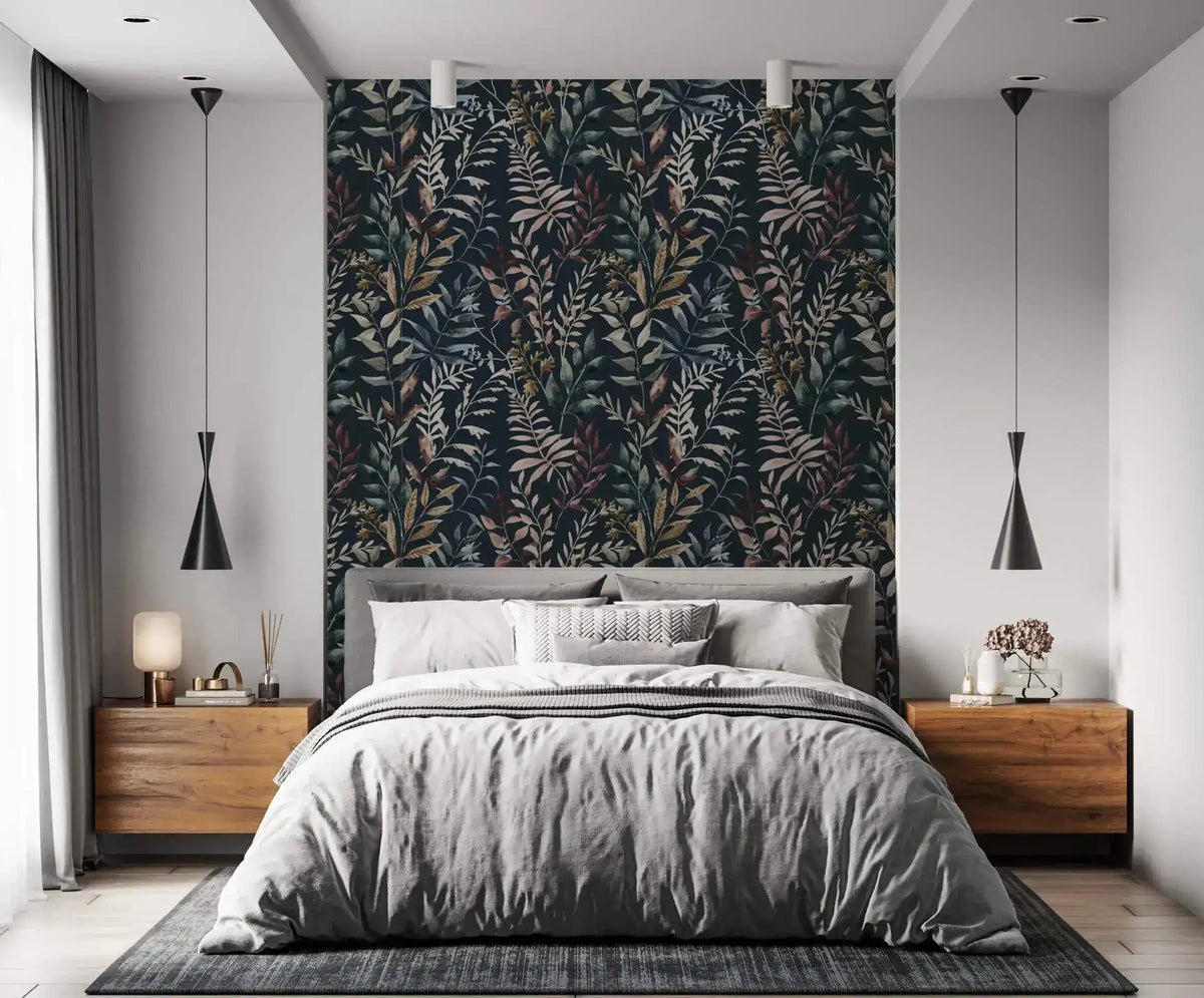 Midnight botanical wallpaper feature wall behind gray upholstered bed with walnut nightstands and black pendant lights.