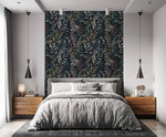Midnight botanical wallpaper feature wall behind gray upholstered bed with walnut nightstands and black pendant lights.