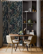 Midnight Botanical wallpaper with dark navy leaf pattern behind round dining table, beige chairs, and shelving unit.