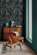 Midnight botanical wallpaper with leaf pattern in corner setting with curved wooden chair and ornate antique dresser.