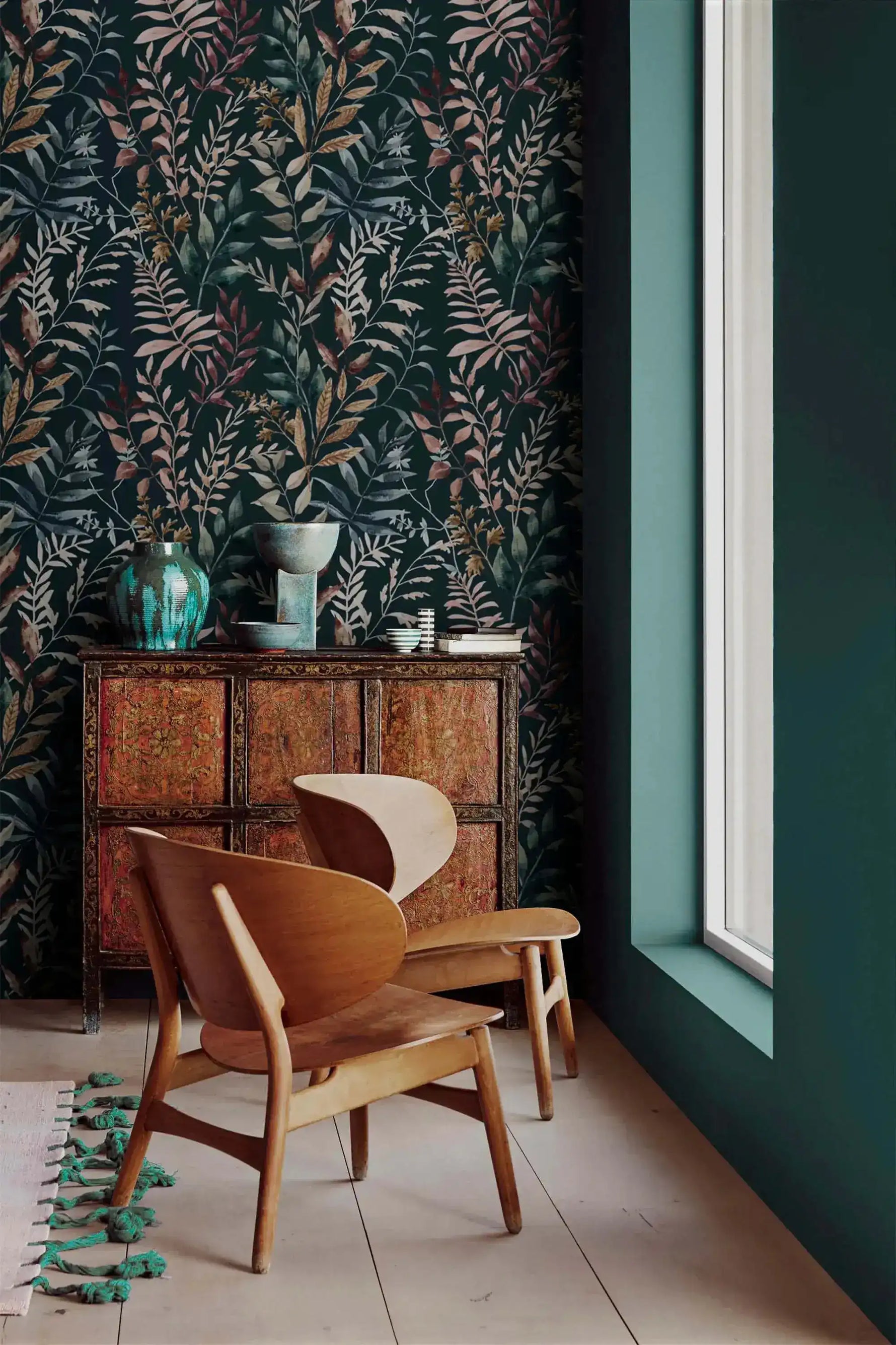 Midnight botanical wallpaper with leaf pattern in corner setting with curved wooden chair and ornate antique dresser.