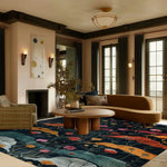 A beautifully styled living room featuring the Midnight Garden Hand Tufted Area Rug. This contemporary floral rug adds a vibrant touch with its colorful floral design on a dark background, perfectly complementing the modern furniture and large windows. Ideal for those seeking large living room rugs with a vintage flair. This wool rug enhances the cozy yet elegant atmosphere in the living room.