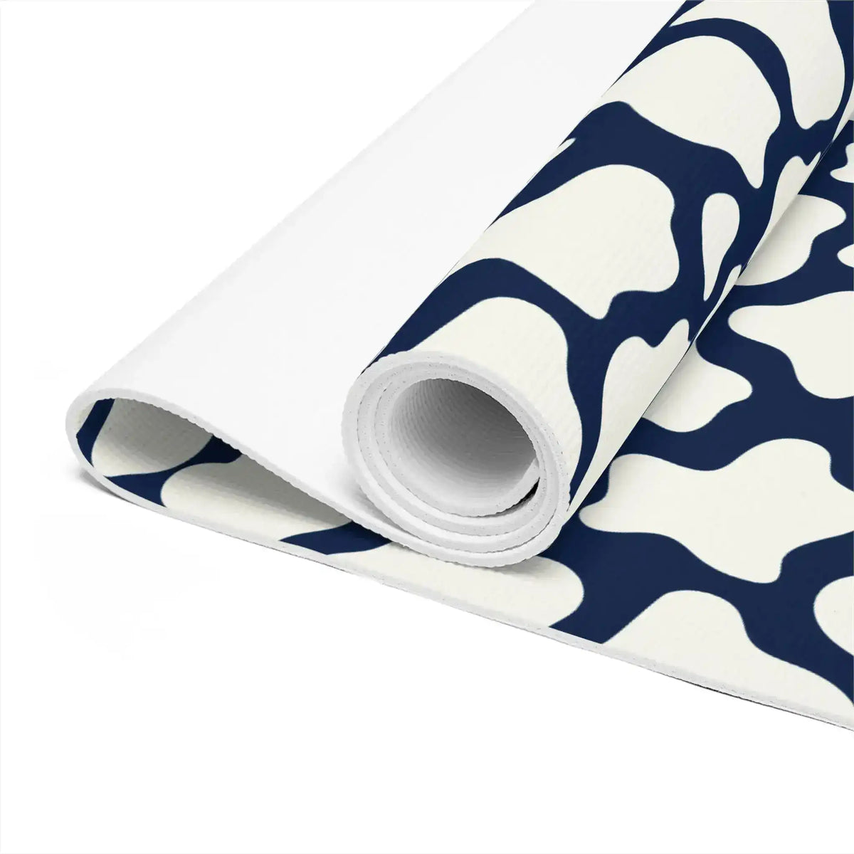 Close-up of the rolled yoga mat revealing its white underside and navy mosaic top