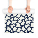 Hands unrolling the navy and cream mosaic yoga mat, textured non-slip surface visible