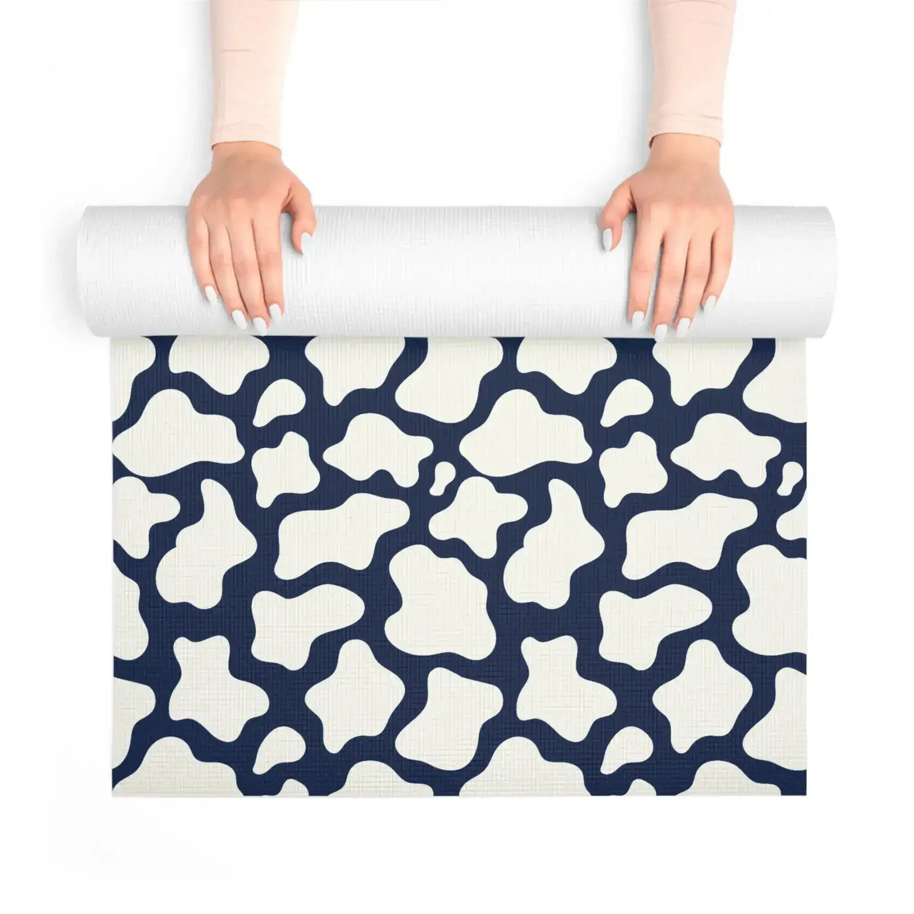Hands unrolling the navy and cream mosaic yoga mat, textured non-slip surface visible