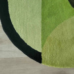 Close-up of the Mini Maia Geometric Round Hand Tufted Wool Rug, showcasing its soft texture and vibrant green tones. Perfect for adding a pop of color to large living room spaces, this round rug is an ideal area rug for living rooms or offices, crafted from high-quality wool.