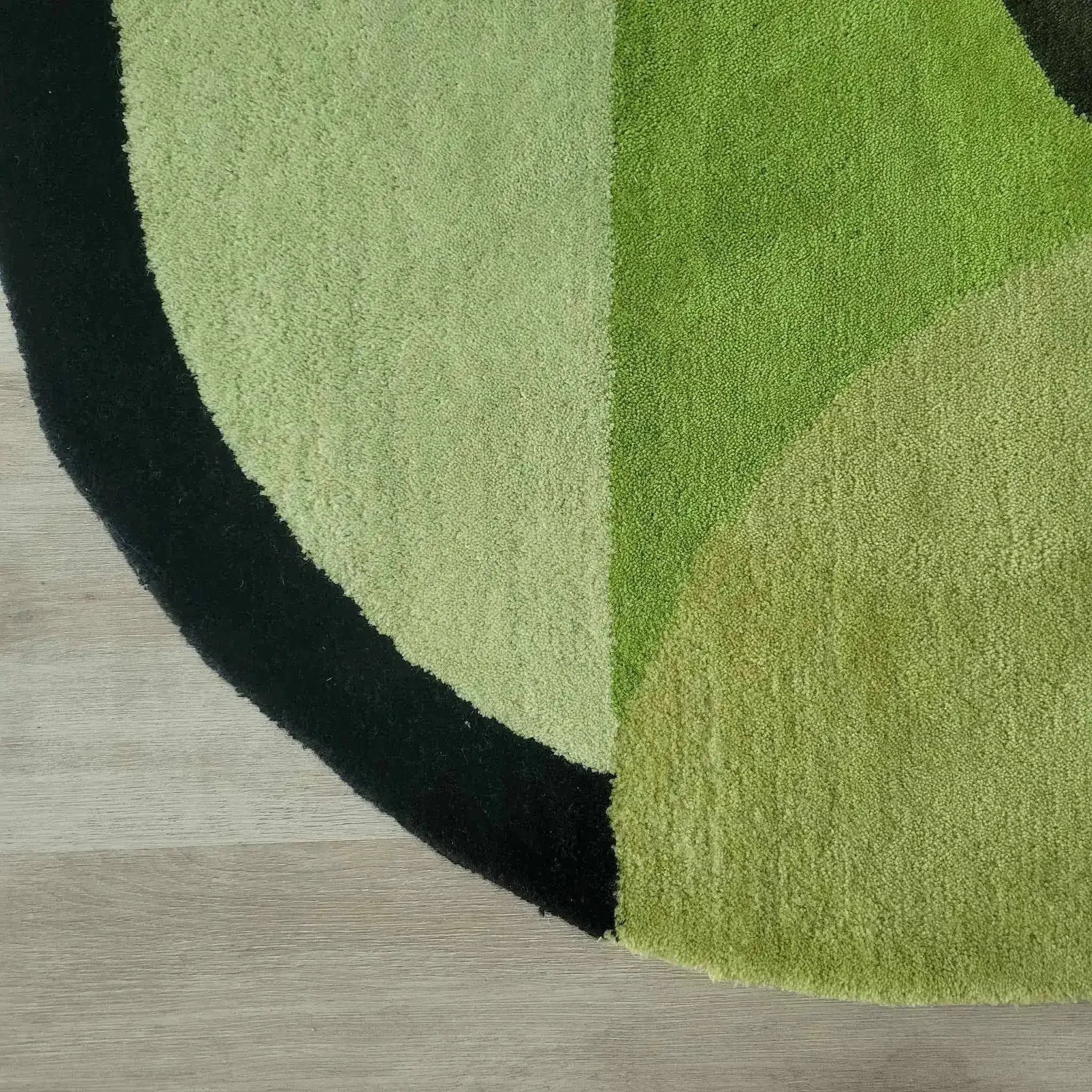 Close-up of the Mini Maia Geometric Round Hand Tufted Wool Rug, showcasing its soft texture and vibrant green tones. Perfect for adding a pop of color to large living room spaces, this round rug is an ideal area rug for living rooms or offices, crafted from high-quality wool.