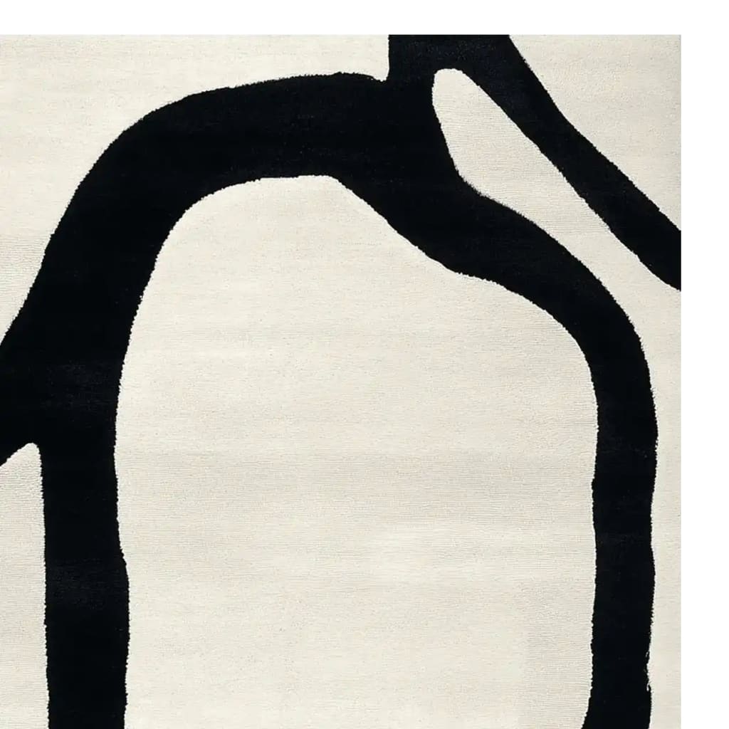 A contemporary area rug featuring a minimalist hand-tufted design with bold black abstract lines on a soft white wool background, perfect for modern living rooms.