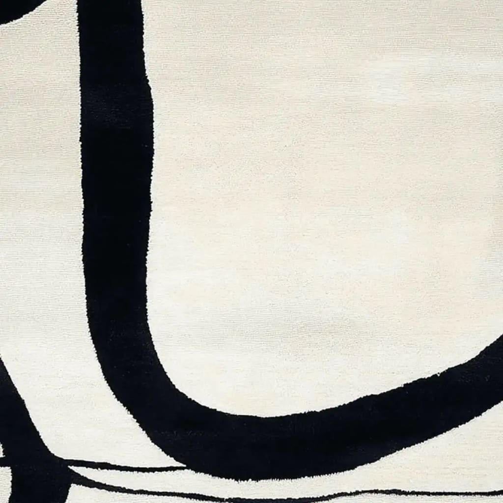 Close-up view of a contemporary area rug featuring a minimalist design with bold black curves against a cream background. This wool rug is perfect for adding a modern touch to your living room decor.