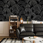 Minimalist Midnight Lines scallop-wave wallpaper over white panelling behind a black leather sofa