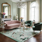 Living room with pink sofa, green armchairs, and floral rug