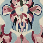 Close-up of a colorful floral pattern on a rug with pink, blue, and black flowers.