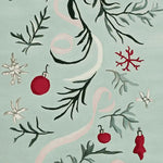 A close-up view of the Mistletoe Ribbon Dance Hand Tufted Area Rug, featuring a festive design with red ornaments and green foliage on a soft background. This wool rug is ideal for adding a touch of holiday charm to living room area rugs, perfect for cozy gatherings. A beautiful choice among area rugs for living room settings.