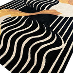 A contemporary Mocha Mirage hand-tufted wool rug featuring an abstract design with flowing black and cream lines, ideal for a formal dining room. This large area rug adds a modern touch to any dining room setting.