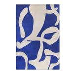 Modern Abstract Blue & White Rug angled corner view — abstract blue pattern on ivory ground, slight perspective showing pile depth