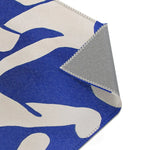 Modern Abstract Blue & White Rug corner fold-back — abstract blue pile face with grey woven backing and overlock stitching visible