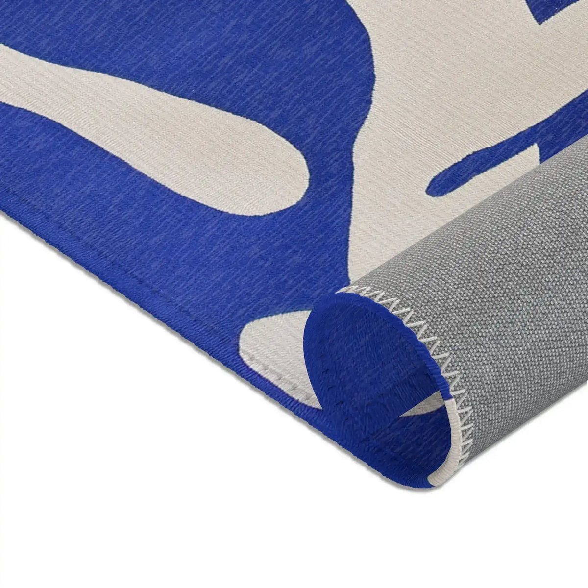 Modern Abstract Blue & White Rug rolled corner close-up — navy pile curling back to reveal cream face backing and grey underside edge