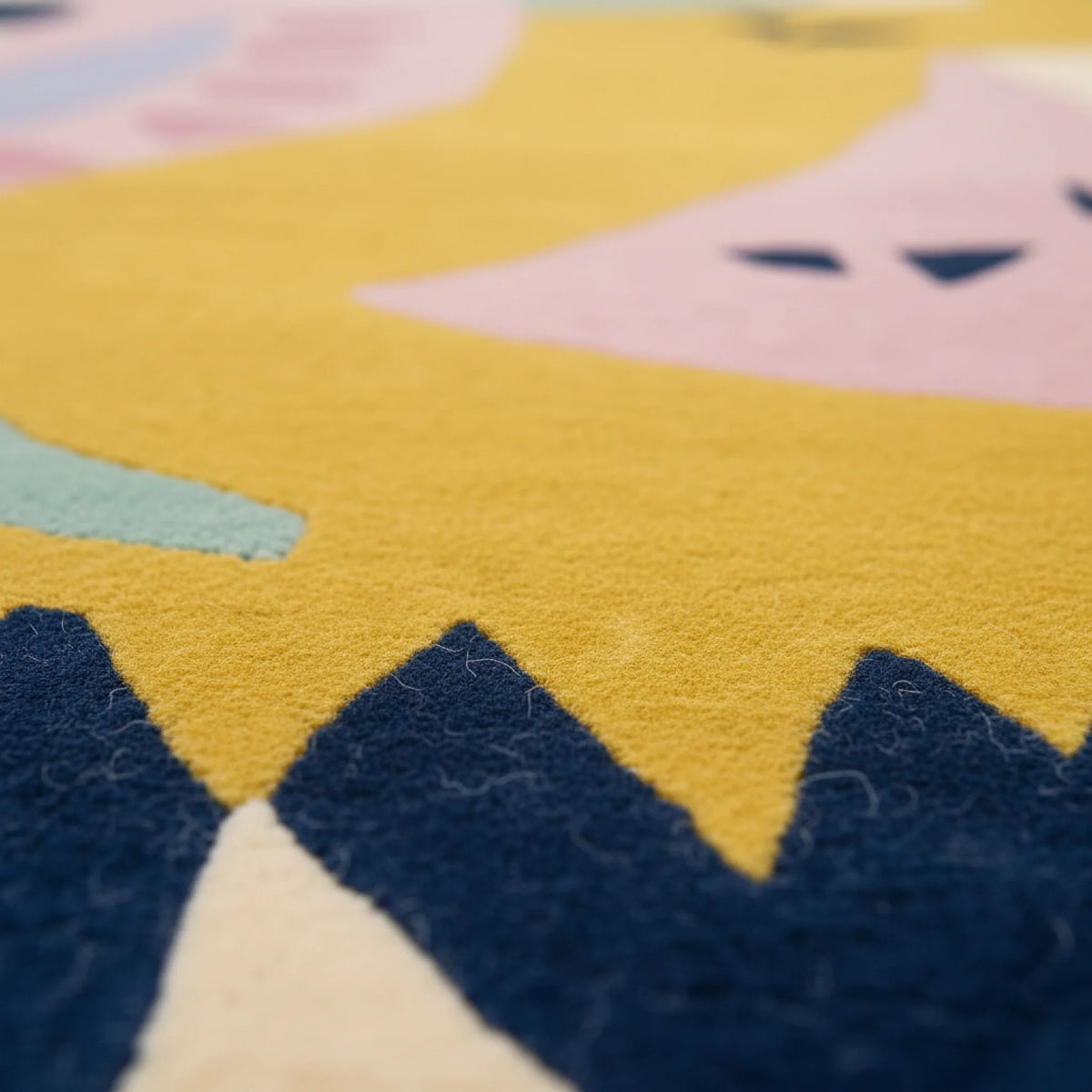Close-up of a colorful star-shaped rug with yellow, blue, and pink colors.