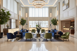 Luxurious hotel lobby with blue sofas,  a contemporary wool rug, green chairs, and decorative elements.