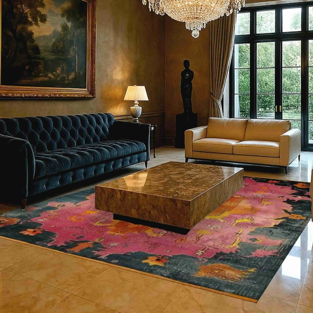 A luxurious living room featuring a modern tribal hard viscose hand knotted wool rug with vibrant abstract patterns. This contemporary area rug, perfect as a dining table rug in a dining room, adds a splash of color with its pink and dark hues. The elegant Persian-style design complements the plush furniture and opulent chandelier, creating a sophisticated ambiance.