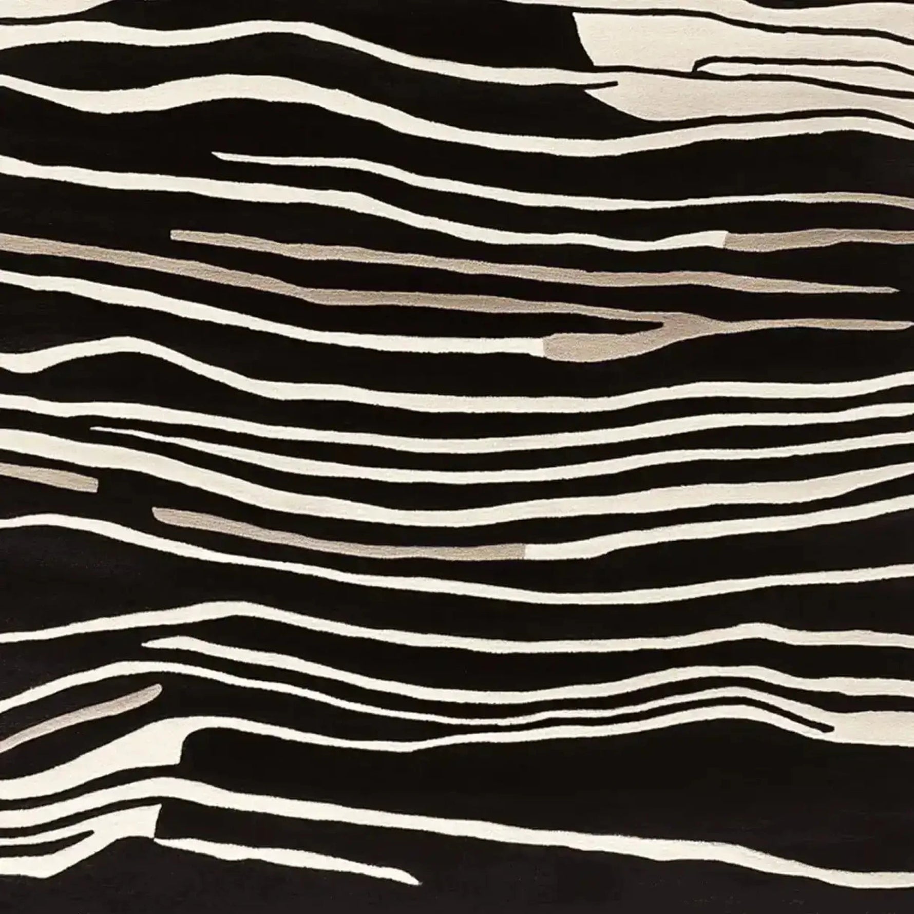 A striking area rug with a black and white abstract pattern, part of the Modular Art Beat collection. This contemporary wool rug, designed for living room spaces, showcases a hand-tufted texture with flowing lines that resemble natural forms.