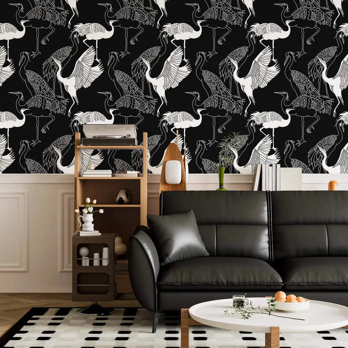 Monochrome crane wallpaper with white cranes on black above wainscoting in a living room with black sofa