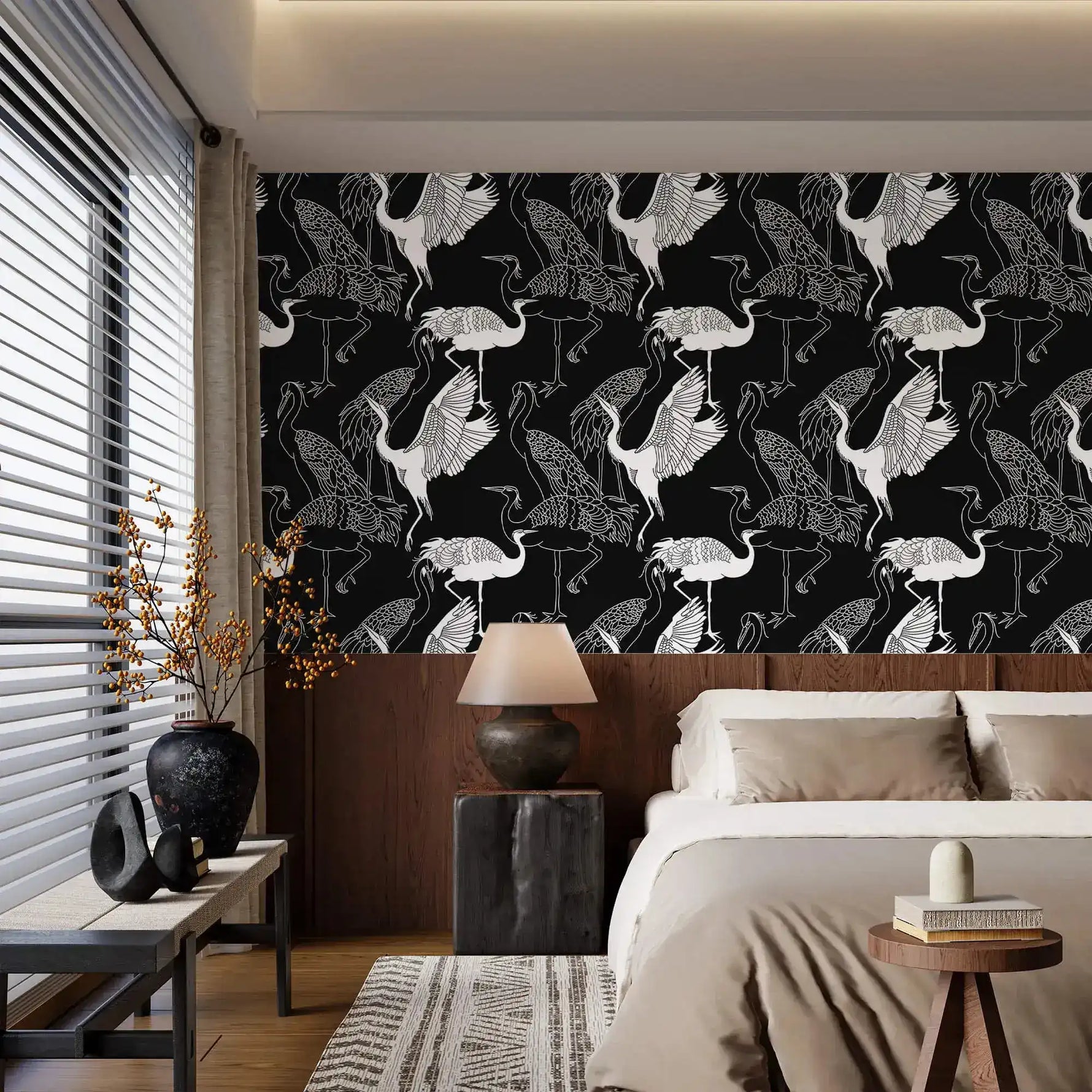 Monochrome crane wallpaper with white cranes on black in a bedroom above a wood headboard and neutral bedding