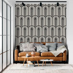 Monochrome Deco fan-pattern feature wall behind a tan leather sofa with grey cushions